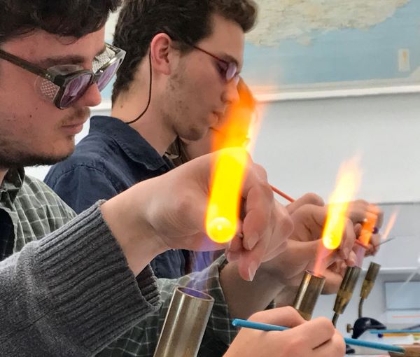Newcastle University students take a lesson in flame-working glass beads from expert Mike Poole in the Wolfson Laboratory